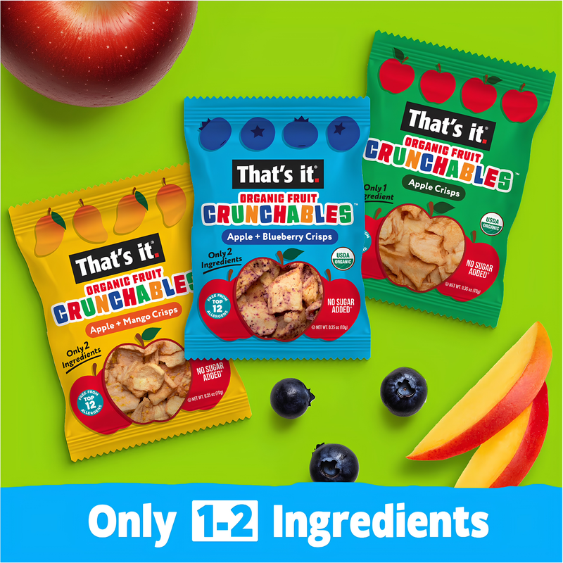 Load image into Gallery viewer, Three bags of That's it! Organic Fruit Crunchables are arranged on a bright green background with fruit props including an apple, blueberries, and peach slices. The packages are yellow, blue, and green, labeled Apple + Mango Crispies, Apple + Blueberry Crispies, and Apple Crispies respectively, with a blue banner at the bottom reading 'Only 1-2 Ingredients'.

